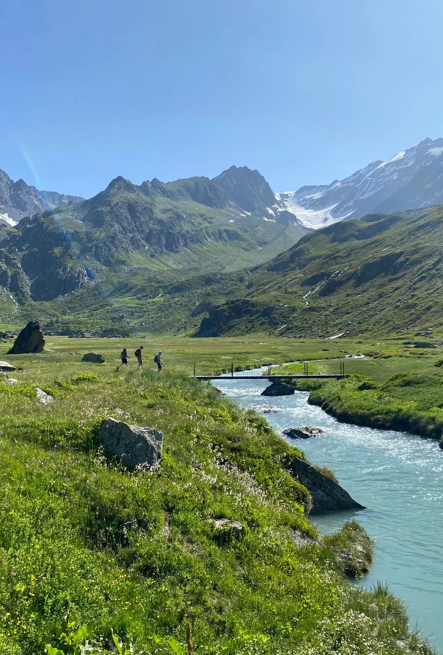 Hiking over a stream in the French Alps in summer.