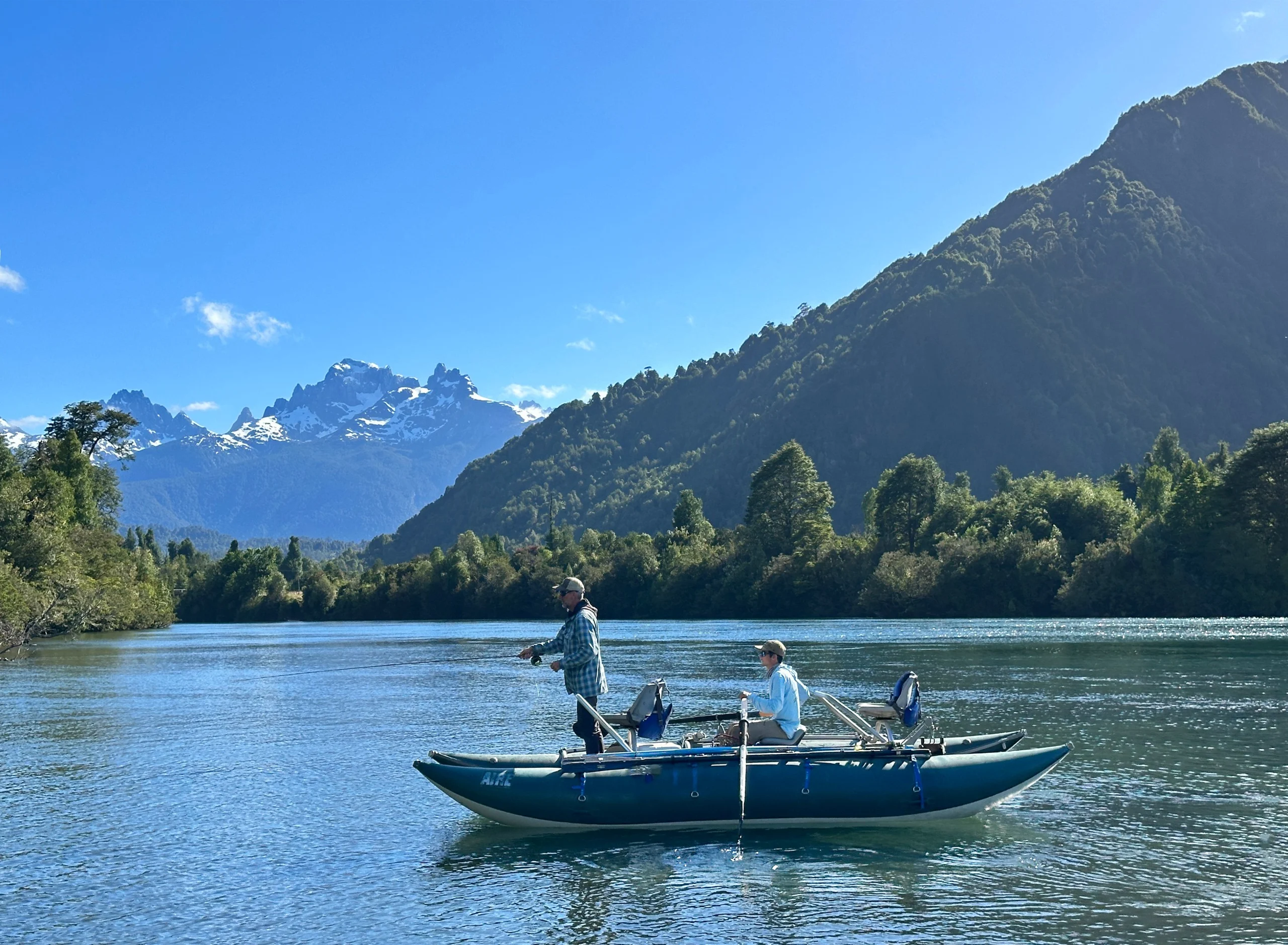 Two people on an inflatable kayak fishing in Rio Yelcho.