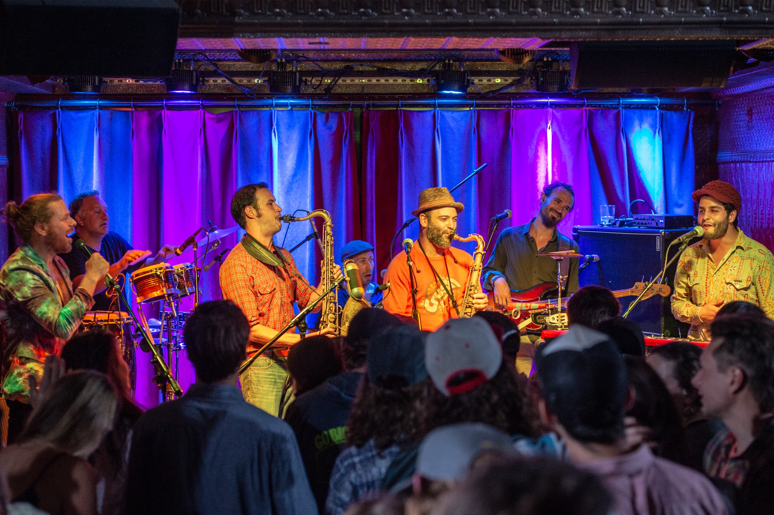 A jazz band performing live to a packed bar.
