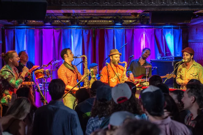 A jazz band performing live to a packed bar.