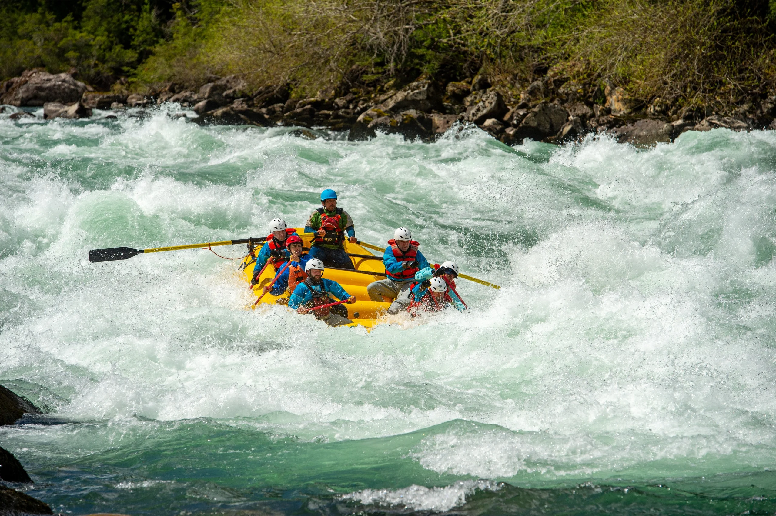 A group on a raft going through large rapids.