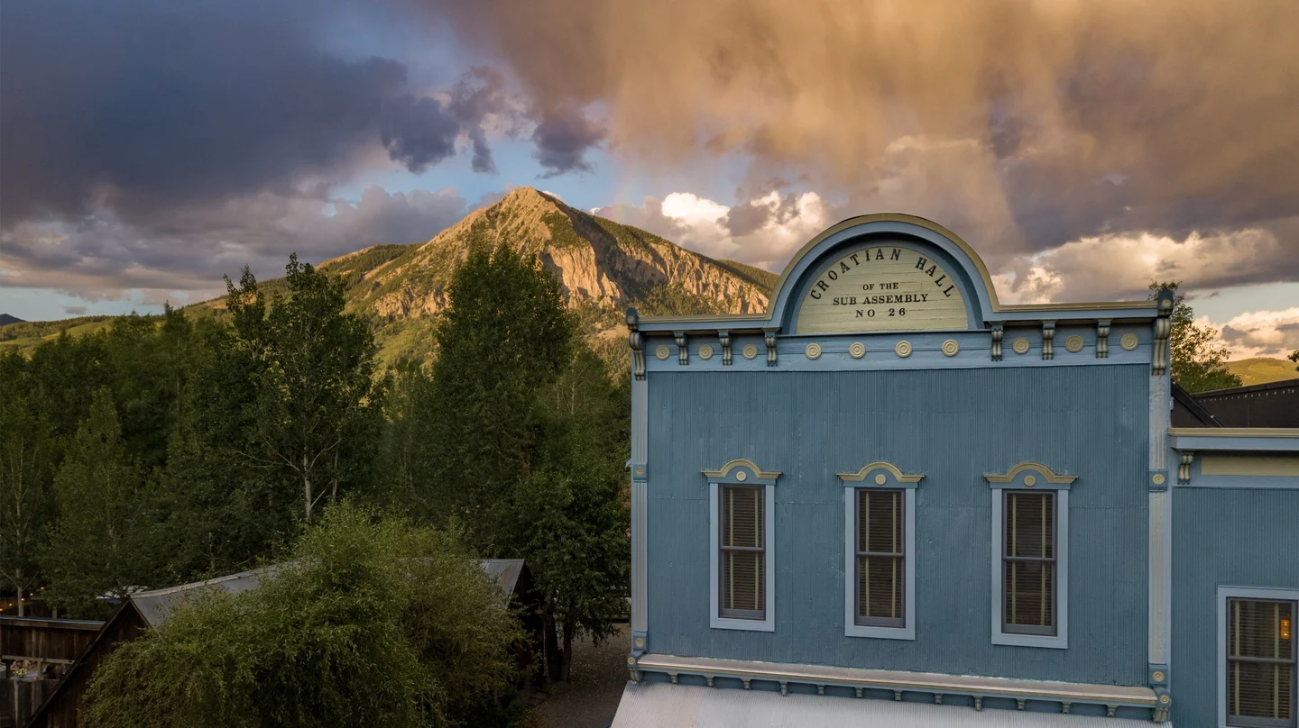 Facade of Scarp Ridge Lodge with a mountain in the distance.