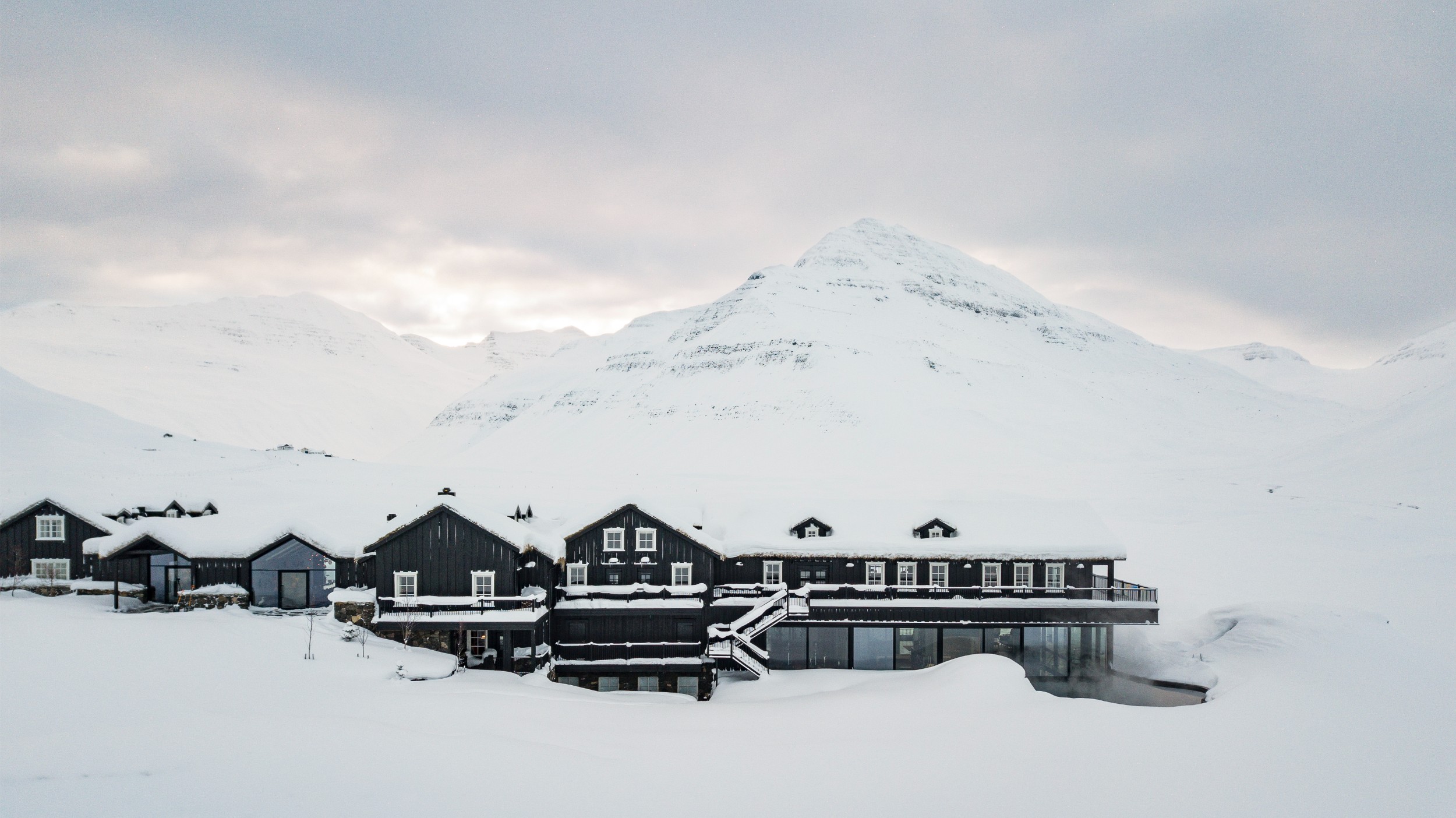 An aerial view of Deplar Farm in a snow covered mountain valley.