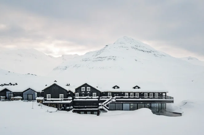 An aerial view of Deplar Farm in a snow covered mountain valley.