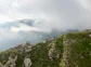 A group of hikers walking on the ridge of a grassy mountain.