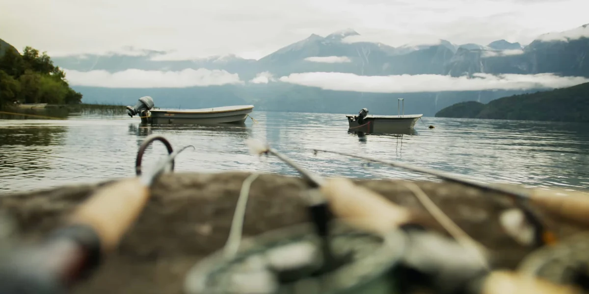 Fly fishing rods in front of the Patagonia scenery and boats
