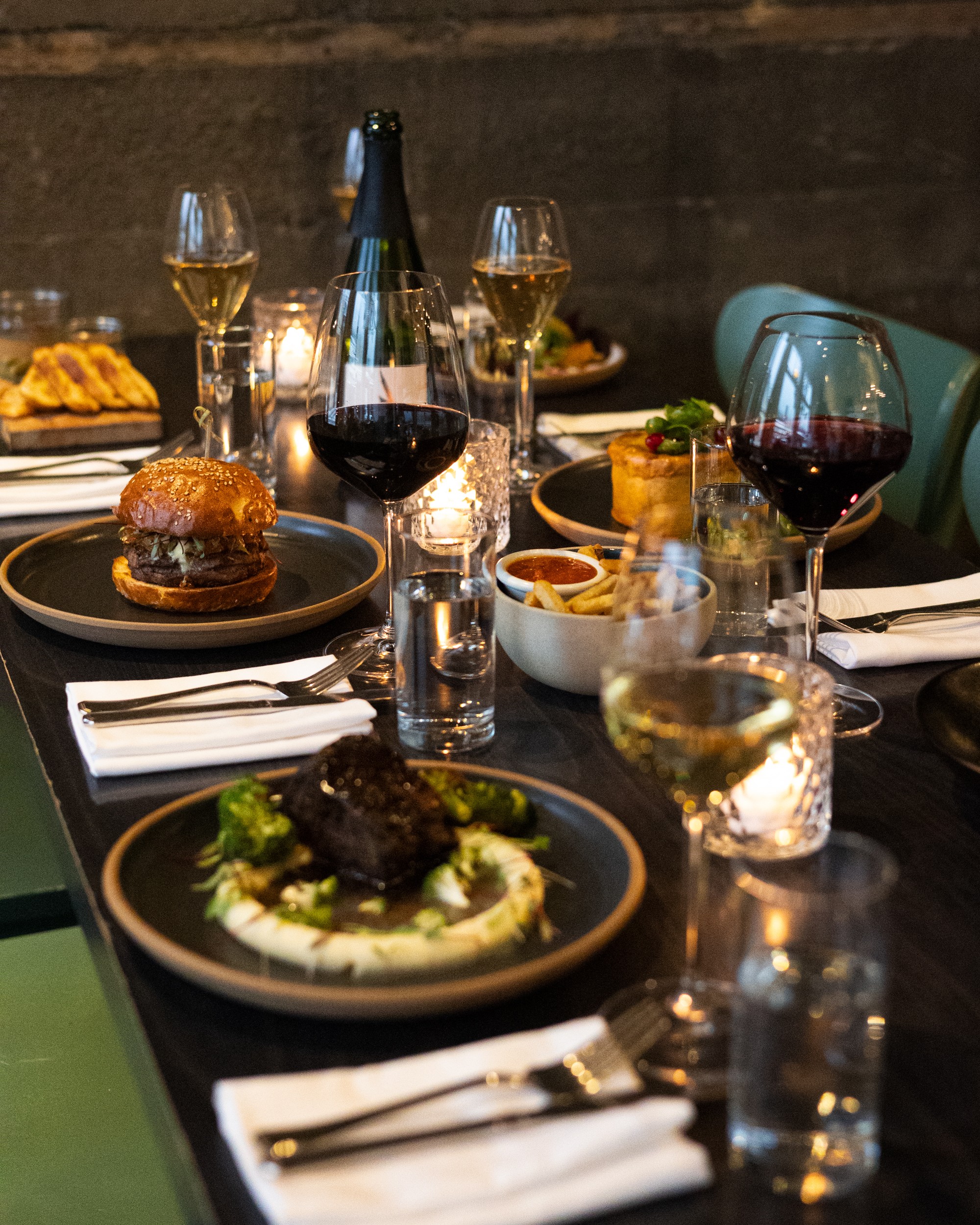 A dinner table with freshly cooked food and wine.