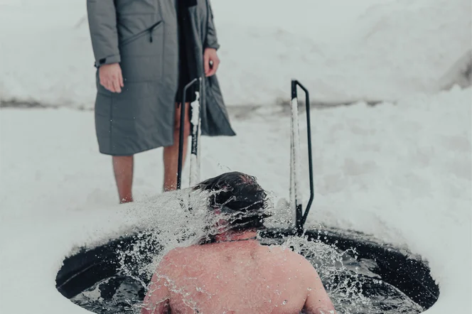 A person taking an ice plunge during a Viking Ritual in Iceland.