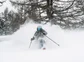 A skier turning at high speeds on a mountain top.