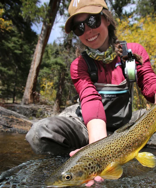 An angler shows off a brown trout.