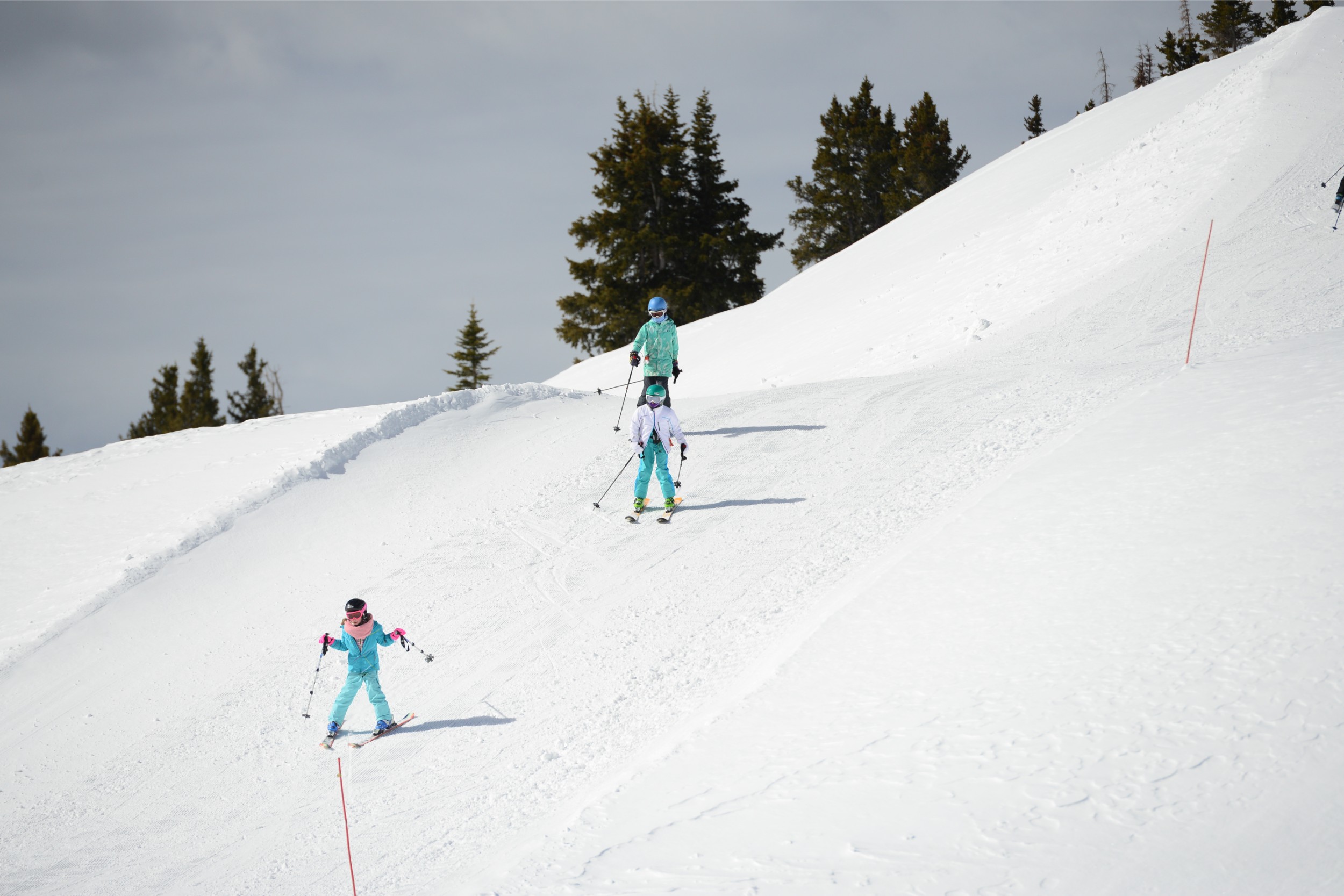 A group of kids skiing down a beginner's slope.