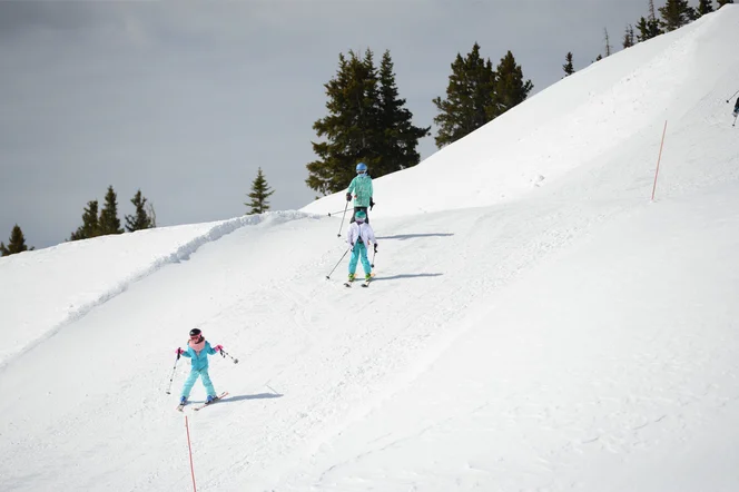 A group of kids skiing down a beginner's slope.