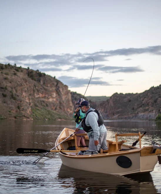 Angler fights a fish from a boat on the Gunnison River.