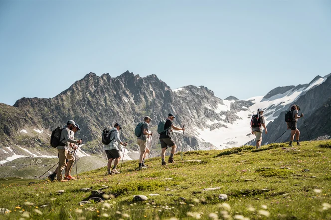 Summer hikers walking to a glacier in the alps.