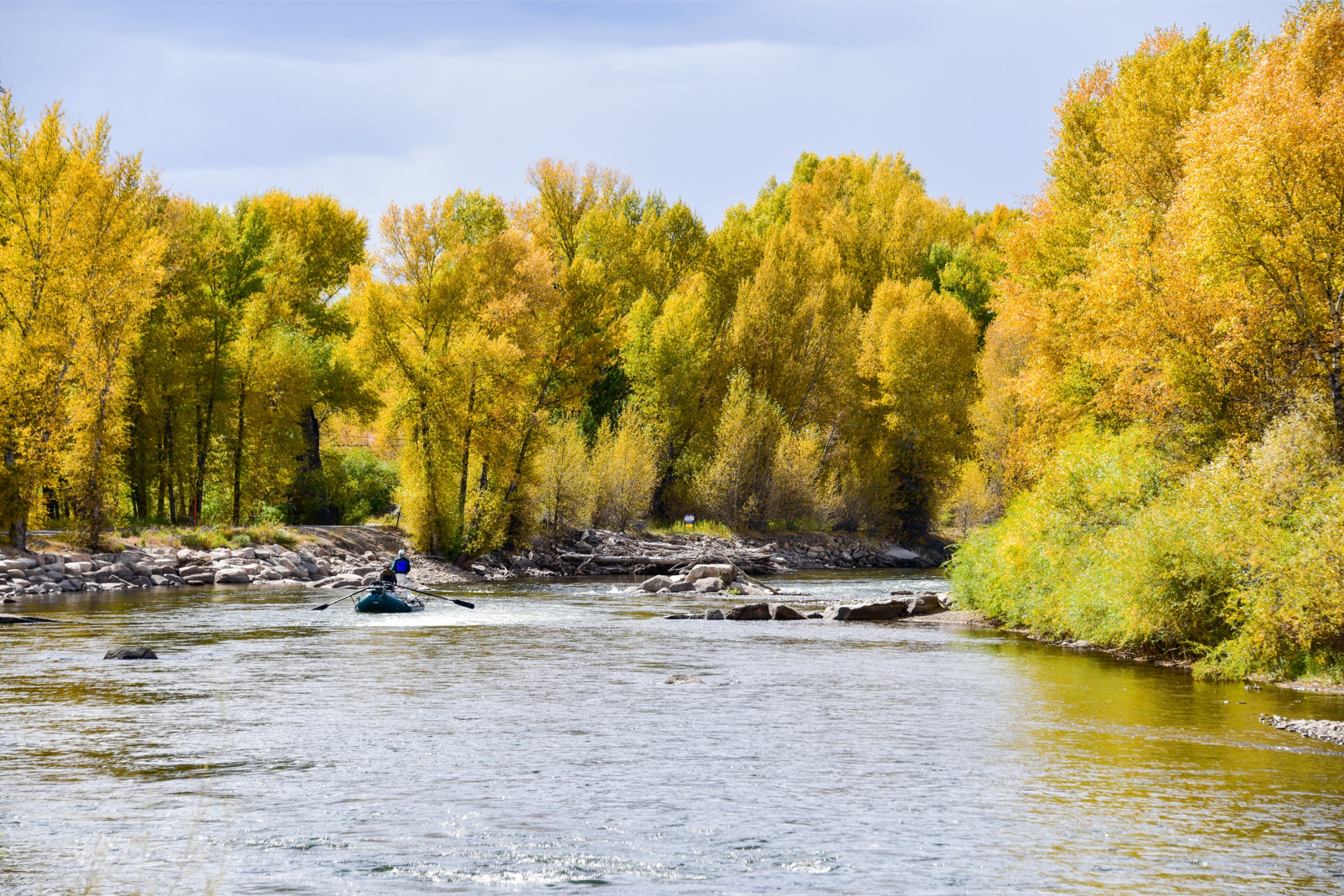 Two fishers rowing down a river in Colorado.