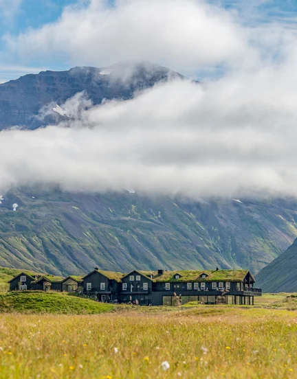 A view of Deplar Farm and the surrounding green mountainous valley.