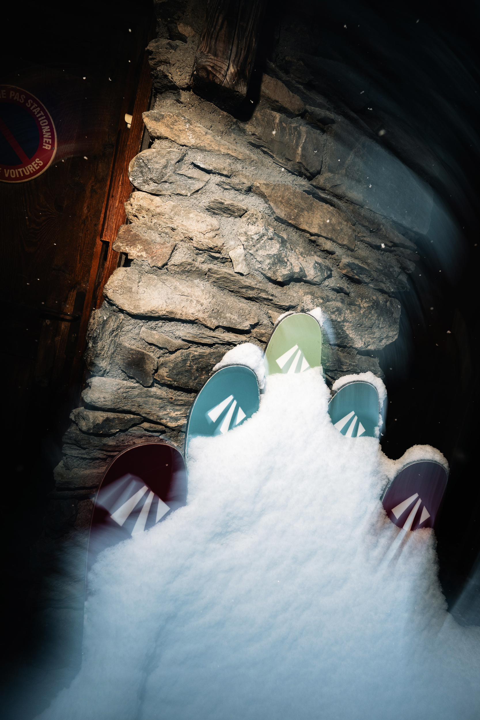 Several pairs of skis up against a lodge in the French Alps