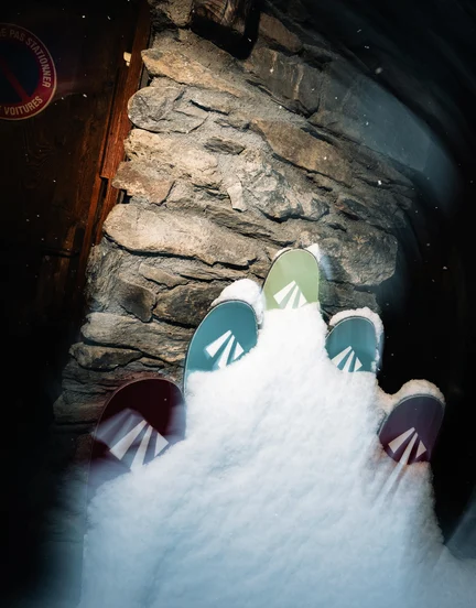 Several pairs of skis up against a lodge in the French Alps