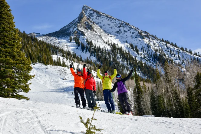 A group of friends celebrating half way down a ski mountain.