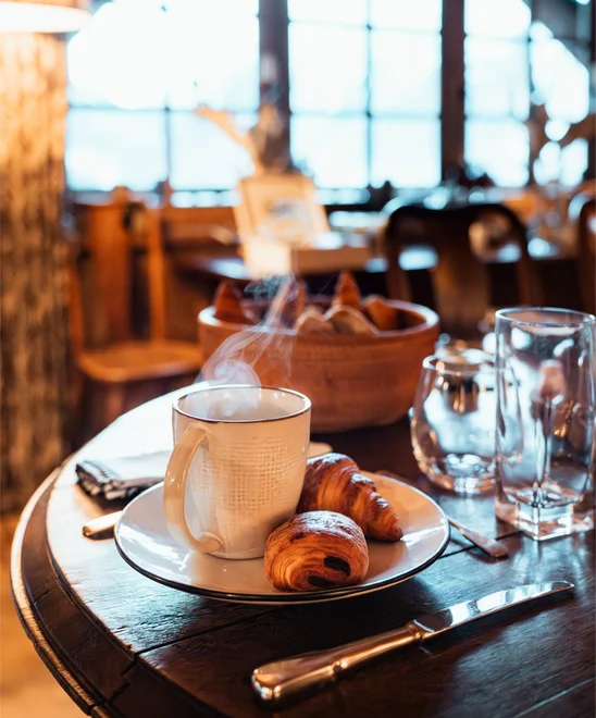 A hot cup of coffee and croissants fresh made for breakfast.