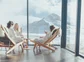 3 people enjoying drinks in spa chairs with views of a mountain.