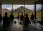 Group of people in a yoga class with a view of mountains.