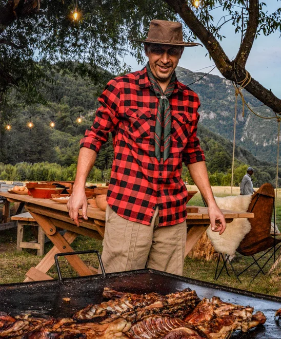 Meat being roasted on a large Asado grill by local Chilean chef.