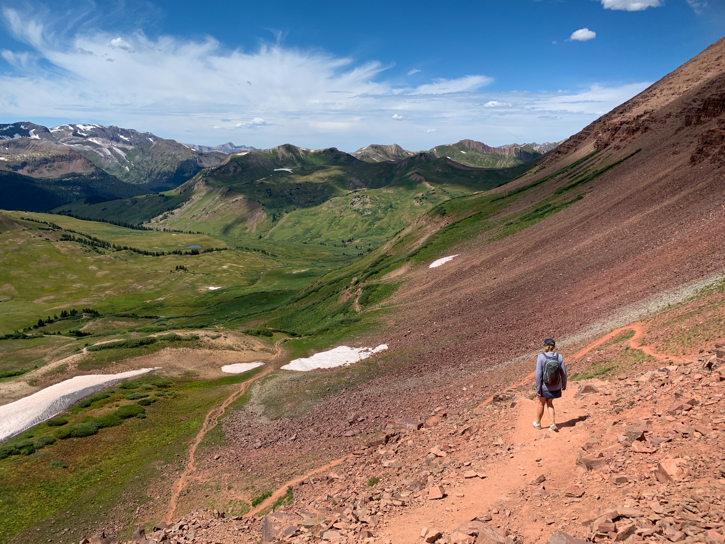 A hiker headed down a rocky hill in the Rockies.