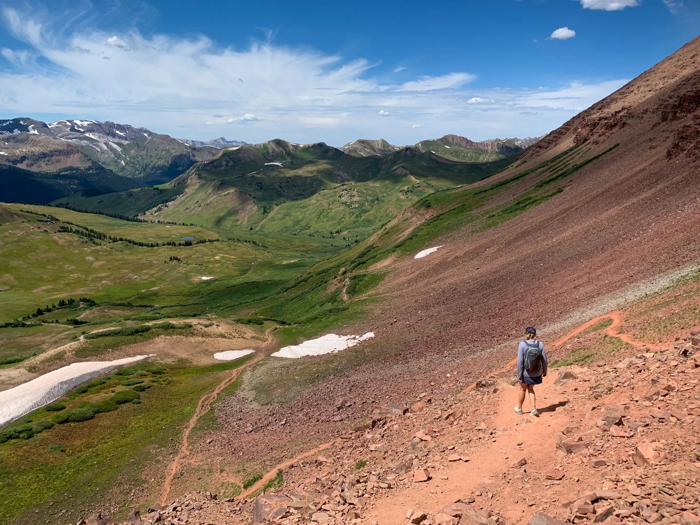 A hiker headed down a rocky hill in the Rockies.