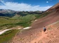 A hiker headed down a rocky hill in the Rockies.