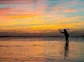 An angler makes a cast at sunset in the Bahamas.