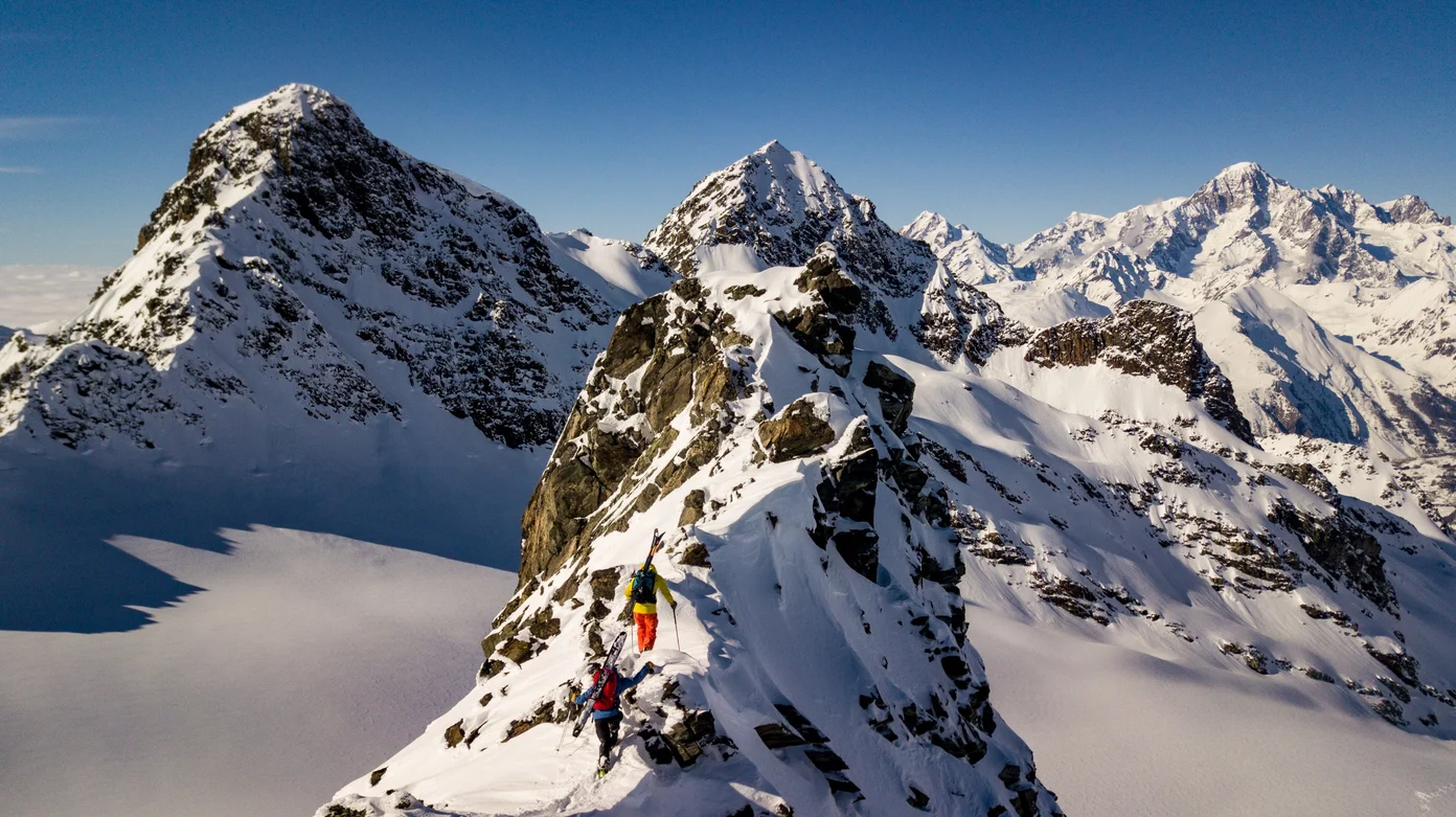 Two skiers hike through the French Alps.
