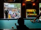 People playing pool next to an outdoor event space with live music and drinks.