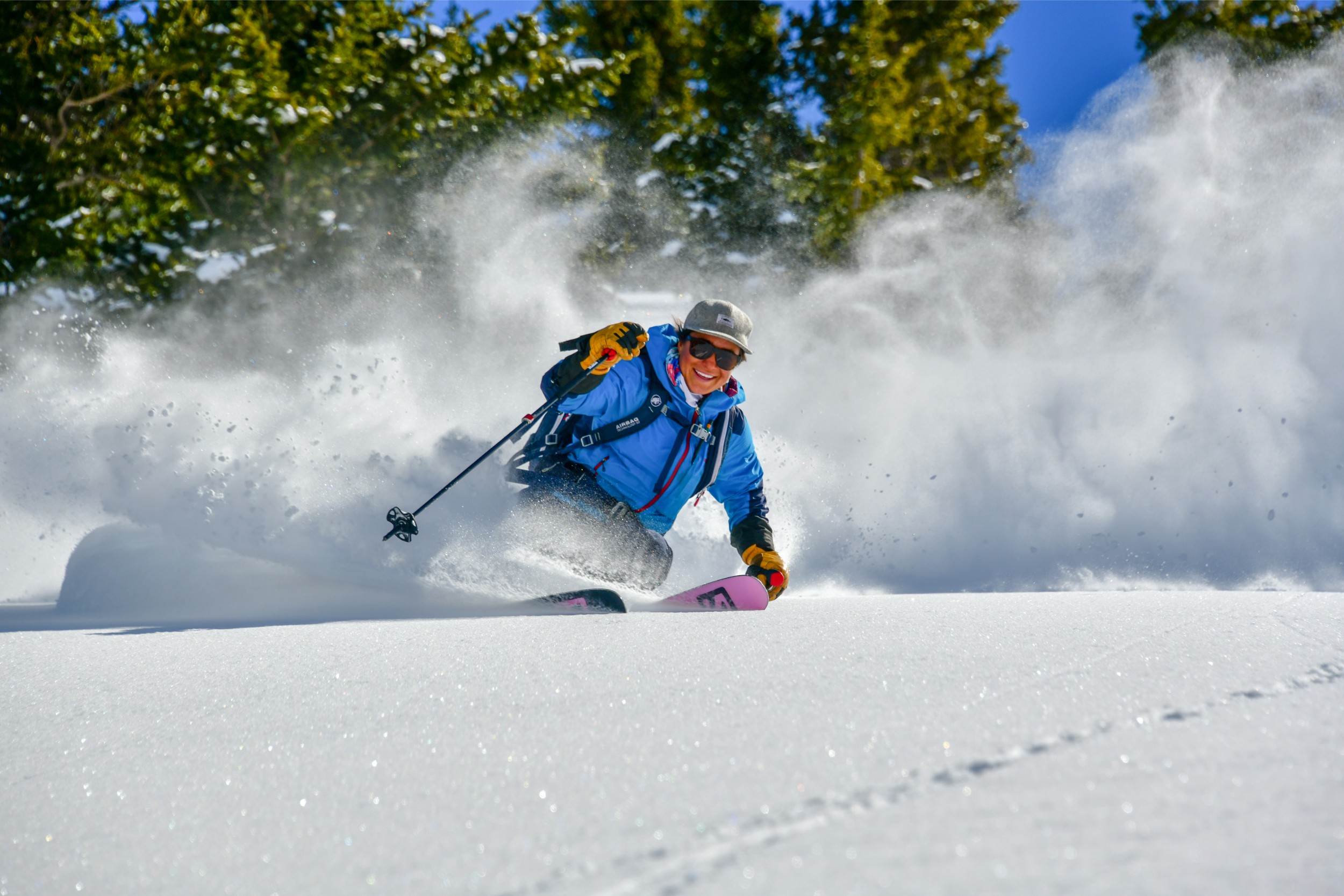 A woman smiling while skiing in Colorado.