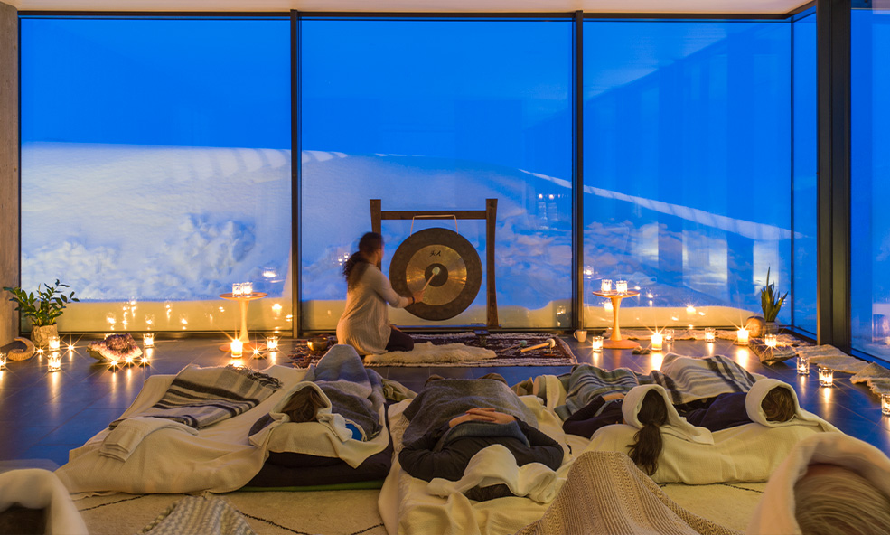 a healing ceremony takes place on a winter evening in a yoga classroom with views of Iceland