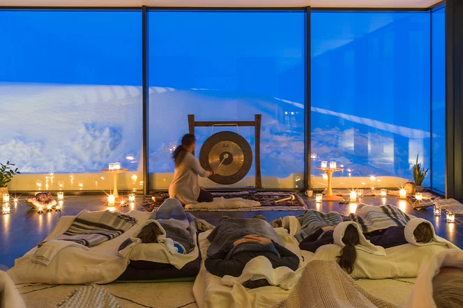 a healing ceremony takes place on a winter evening in a yoga classroom with views of Iceland