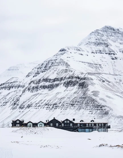 Deplar Farm covered in snow with a mountain behind it.