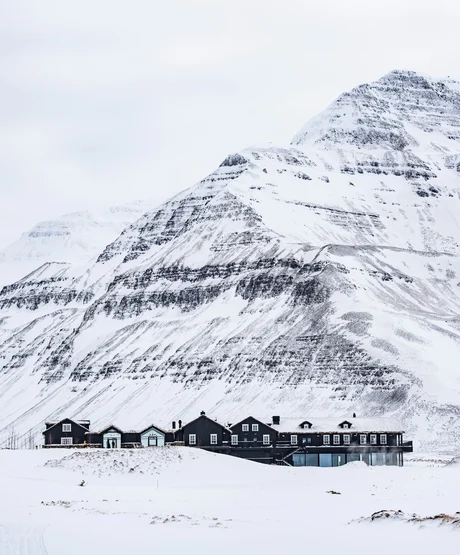Deplar Farm covered in snow with a mountain behind it.