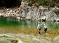 Two people wearing waders fly fishing in the middle of Owen River.