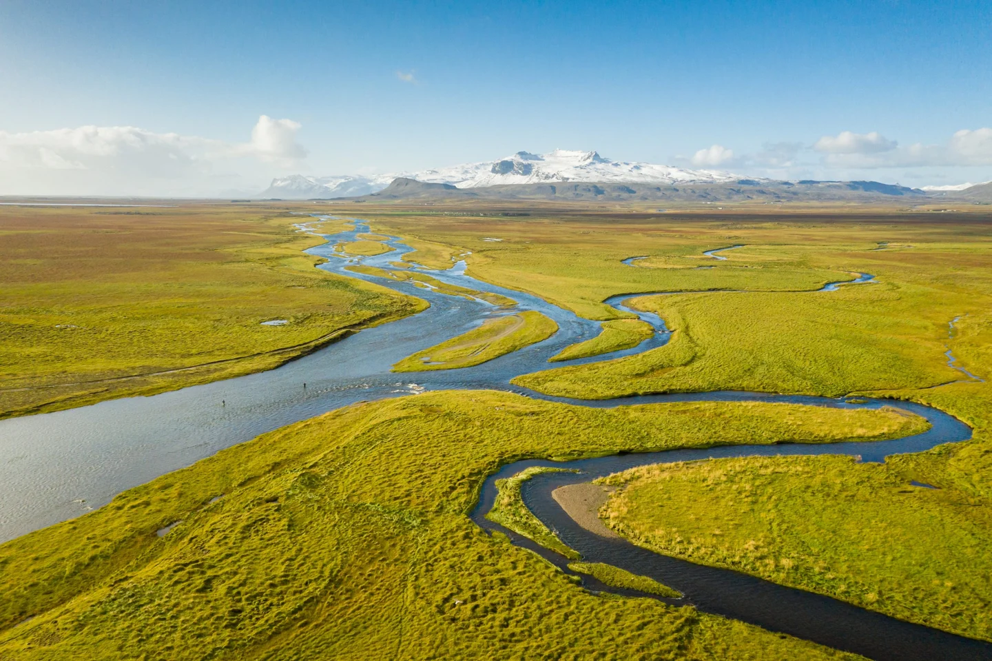 The Husey River in Iceland meanders through a field.