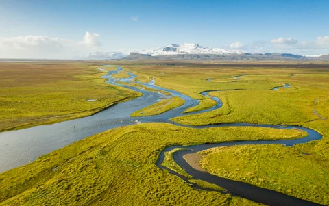The Husey River in Iceland meanders through a field.