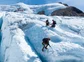 A group of climbers using ice picks to cross a glacier in Chile.