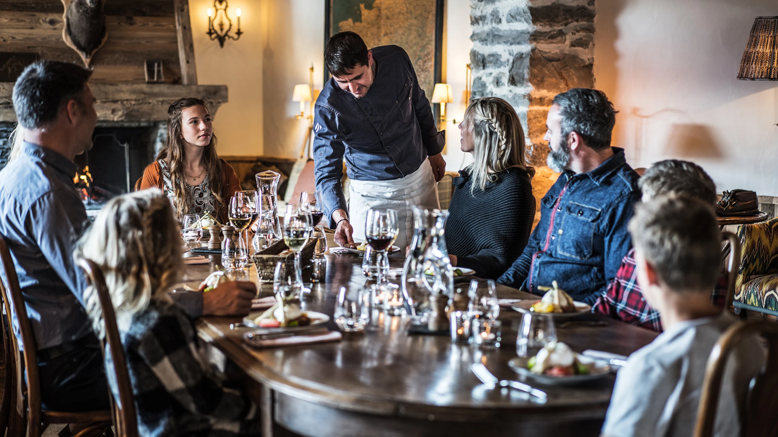 Chef serving family in French lodge.