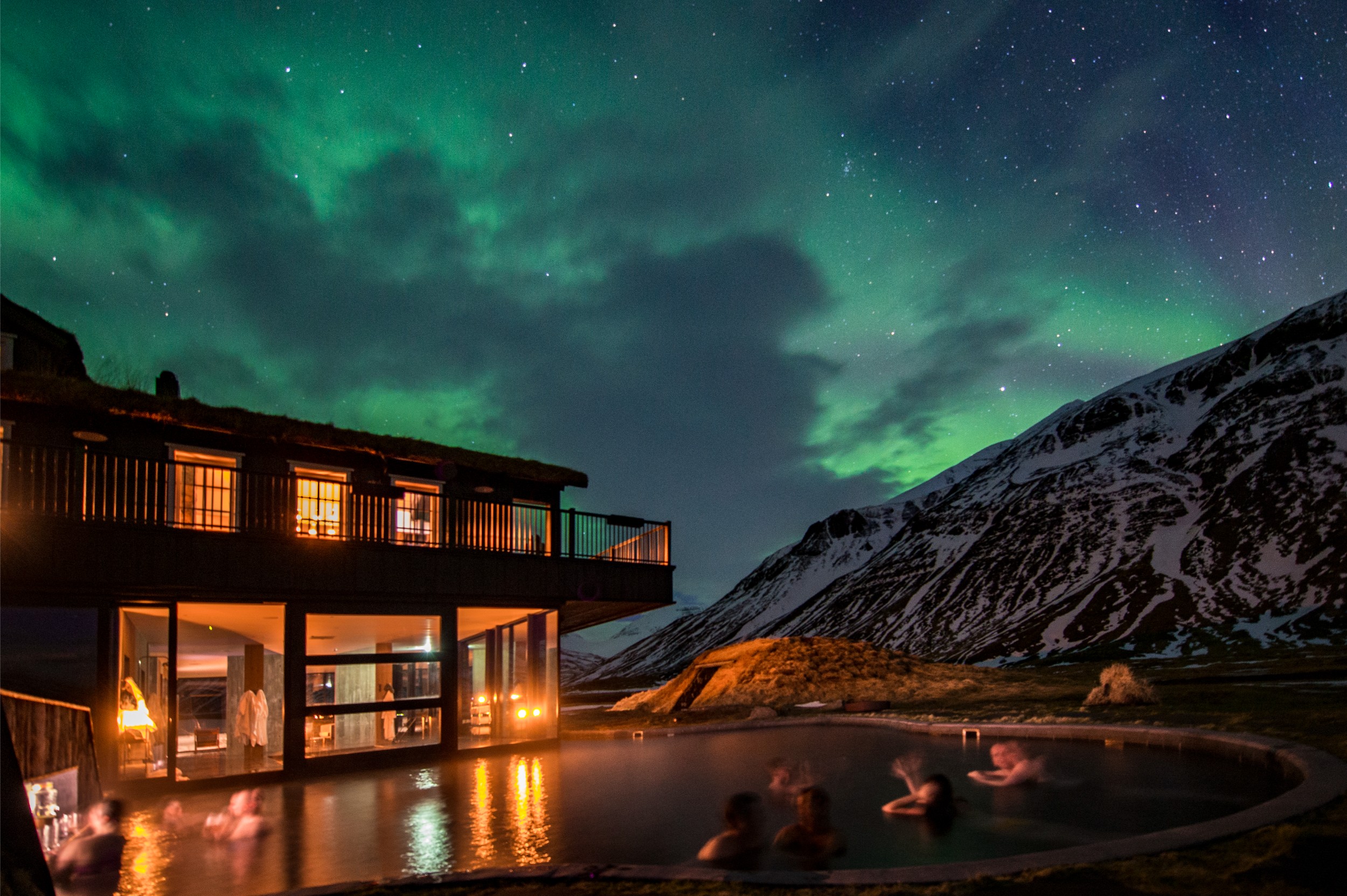 Outdoor heated pool at night at Deplar Farm Lodge with the Northern Lights in the sky.