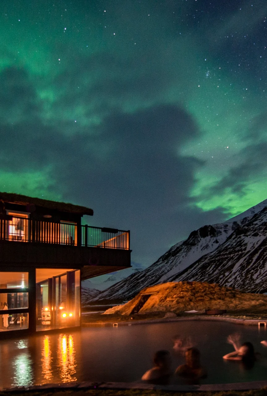 Outdoor heated pool at night at Deplar Farm Lodge with the Northern Lights in the sky.