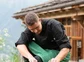 A chef picking local herbs outside of a house in the valley.