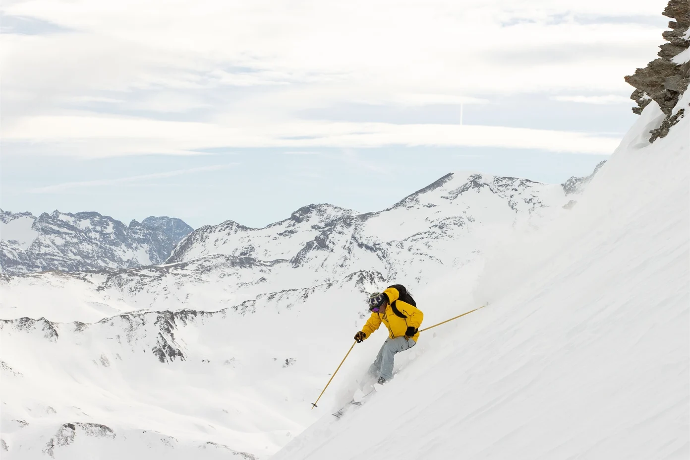 Man skiing down a steep mountain side.