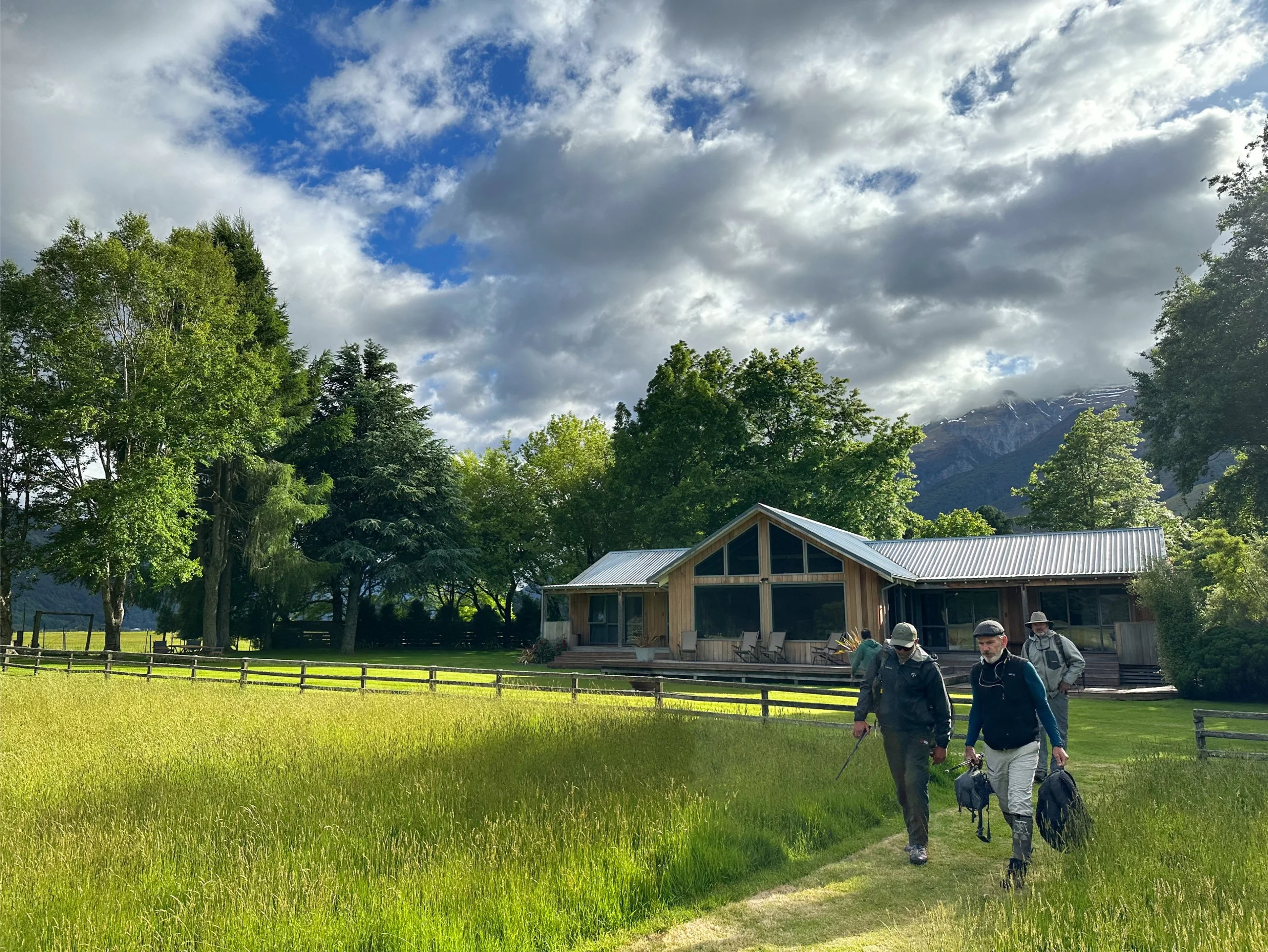 Group of people walking on trail in front of Cedar Lodge.