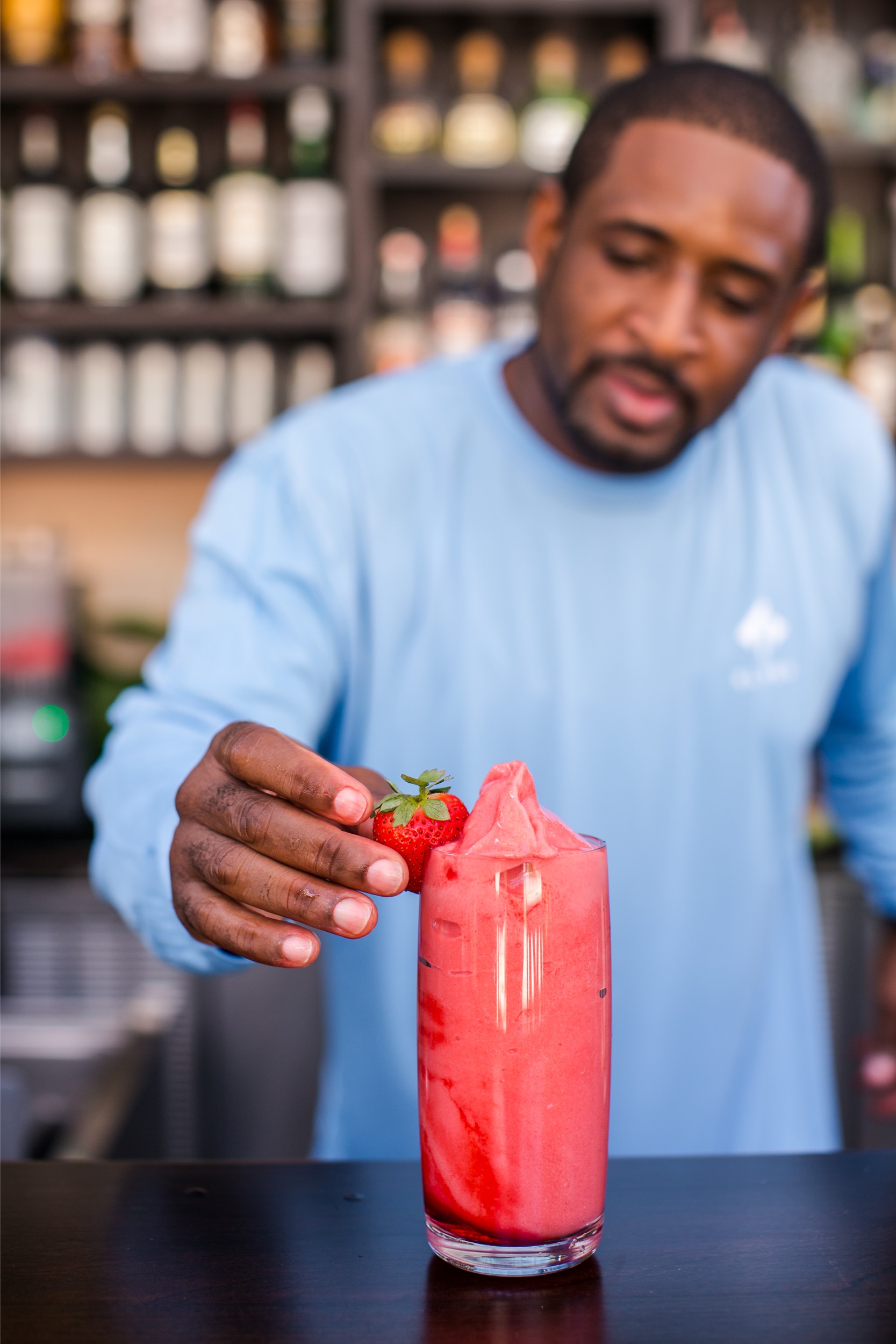 Water puts finishing touches on a pink tiki drink.