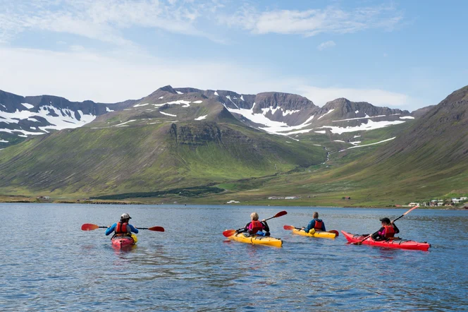 A group of people kayaking in a mountain valley.